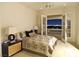 A bedroom has neutral tones with a balcony that offers spectacular views of the city skyline at night at 5030 Spanish Hills Dr, Las Vegas, NV 89148