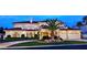 Elegant home showcasing lush landscaping, arched windows, and attached garage at 5030 Spanish Hills Dr, Las Vegas, NV 89148