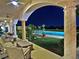 A covered outdoor patio with plush seating offers picturesque views of the pool and the surrounding landscape at 5030 Spanish Hills Dr, Las Vegas, NV 89148