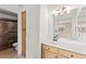 Bright bathroom featuring a sink with wooden cabinet and a shower with brown tiles at 5615 Calais Ct, Las Vegas, NV 89118