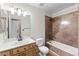 Bright bathroom with wooden cabinets, white sink, and a shower with brown tiles and bathtub at 5615 Calais Ct, Las Vegas, NV 89118