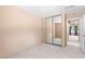 Bedroom with tan walls, neutral carpet, mirrored closet, and a hallway view at 5615 Calais Ct, Las Vegas, NV 89118