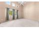 Vaulted ceiling bedroom featuring a ceiling fan, large windows, and neutral decor at 5615 Calais Ct, Las Vegas, NV 89118