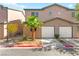 Inviting townhome features a two-car garage, desert landscaping, and modern architectural details at 5615 Calais Ct, Las Vegas, NV 89118