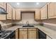 Kitchen area with wooden cabinetry, a gas stove, granite countertops and modern appliances at 5615 Calais Ct, Las Vegas, NV 89118