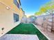 Cozy backyard features artificial grass, a brick wall, and hardscape at 5653 Mount Athos St, North Las Vegas, NV 89031