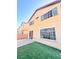 Home featuring a small, easy-care backyard with artificial turf and brick patio at 5653 Mount Athos St, North Las Vegas, NV 89031