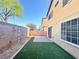 Low-maintenance backyard includes artificial turf and a tiled patio area for relaxing at 5653 Mount Athos St, North Las Vegas, NV 89031