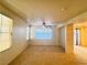 Bright living room with large windows, neutral carpet, and ceiling fan at 5653 Mount Athos St, North Las Vegas, NV 89031