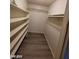 A walk in closet with multiple shelves and a wooden floor at 615 S Royal Crest Cir # 10, Las Vegas, NV 89169