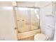 Bathroom with a toilet, enclosed bathtub with a sliding door, and a cabinet at 6233 Overhang Ave, Henderson, NV 89011