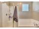 Bright bathroom featuring a tub, glass-enclosed shower, and neutral color scheme at 6334 Orions Belt Peak St, North Las Vegas, NV 89031