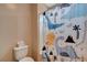 The bathroom showcases a playful dinosaur-themed shower curtain and stacked towels at 6334 Orions Belt Peak St, North Las Vegas, NV 89031