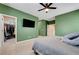 View of a carpeted bedroom with a walk-in closet and TV on the wall, illuminated by recessed lighting at 6334 Orions Belt Peak St, North Las Vegas, NV 89031