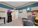 Inviting bedroom with a comfortable gray armchair and a retro Arcade Up game console at 6334 Orions Belt Peak St, North Las Vegas, NV 89031