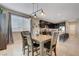 Bright dining area featuring a wooden table set, modern lighting fixtures, and an open flow to the kitchen at 6334 Orions Belt Peak St, North Las Vegas, NV 89031