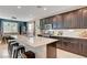 Kitchen with an island, granite countertops, dark cabinets, stainless appliances, and bar stool seating at 6334 Orions Belt Peak St, North Las Vegas, NV 89031