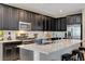 Open kitchen with dark cabinets, granite countertops, stainless steel appliances, and an island with bar seating at 6334 Orions Belt Peak St, North Las Vegas, NV 89031