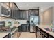 Modern kitchen featuring granite countertops, stainless steel appliances, dark cabinetry, and ample counter space at 6334 Orions Belt Peak St, North Las Vegas, NV 89031