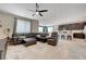 Open-concept living room features tile floors, ceiling fan, and leather furniture near the kitchen at 6334 Orions Belt Peak St, North Las Vegas, NV 89031