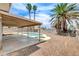 Backyard showcasing a covered patio, pool, lush landscaping, and desert style plantings at 7004 Powderhorn Cir, Las Vegas, NV 89128