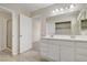 Bathroom featuring a double sink vanity and view to a nearby shower and bedroom at 7004 Powderhorn Cir, Las Vegas, NV 89128