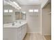 Bright bathroom featuring a double sink vanity, large mirror, and laminate flooring at 7004 Powderhorn Cir, Las Vegas, NV 89128