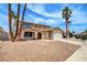 Charming two-story home featuring desert landscaping and palm trees at 7004 Powderhorn Cir, Las Vegas, NV 89128