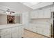 Bright kitchen boasts white cabinets, tile flooring and a convenient center island at 7004 Powderhorn Cir, Las Vegas, NV 89128