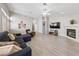 Bright living room featuring gray wood-look floors, fireplace, and multiple ceiling fans at 8316 Joseph Cary Ct, Las Vegas, NV 89145