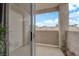 Private balcony with stucco wall, door and glimpses of the community rooflines and sunny blue sky at 855 N Stephanie St # 2121, Henderson, NV 89014