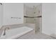 Relaxing bathroom with a luxurious soaking tub and a glass-enclosed shower, complemented by sleek tile at 855 N Stephanie St # 2121, Henderson, NV 89014