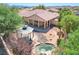 Beautiful backyard with a covered patio, decorative rocks, lovely gazebo, pond feature, and mature trees at 9092 National Park Dr, Las Vegas, NV 89178