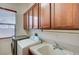 Laundry room with washer, dryer, sink, and upper cabinets for ample storage at 9092 National Park Dr, Las Vegas, NV 89178