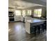Well lit kitchen featuring white cabinetry, quartz countertops, stainless appliances and island with stool seating at 9485 Supernova Ct, Las Vegas, NV 89123