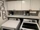 Well-organized laundry room with white cabinets and front load washer and dryer at 9485 Supernova Ct, Las Vegas, NV 89123