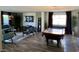 Open-concept living area with comfortable seating, pool table, and view of the backyard at 9485 Supernova Ct, Las Vegas, NV 89123