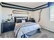 Stylish bedroom with bold, dark blue trim, modern furnishings, and decor creating a serene and masculine retreat at 9576 Archer Peak Ct, Las Vegas, NV 89143