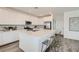 Bright kitchen with white cabinets, quartz countertops, an island with seating, and black backsplash at 9576 Archer Peak Ct, Las Vegas, NV 89143