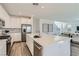 Open kitchen with stainless steel appliances, a large island with a sink, and sleek cabinetry at 9576 Archer Peak Ct, Las Vegas, NV 89143