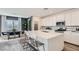 Modern kitchen with white cabinetry, quartz countertops, large island, and dining area at 9576 Archer Peak Ct, Las Vegas, NV 89143