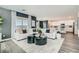 Open-concept living room featuring white sofas, dark accent wall, and seamless transition to the kitchen at 9576 Archer Peak Ct, Las Vegas, NV 89143
