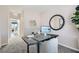 Modern home office space featuring neutral walls, carpeted floors, and a stylish round mirror at 9576 Archer Peak Ct, Las Vegas, NV 89143