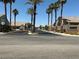 Gated community entrance with lush landscaping and mature palm trees at 9753 Arrowcrest Ave, Las Vegas, NV 89147