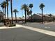 A gated community entrance with desert landscaping, enhanced by lush palm trees at 9753 Arrowcrest Ave, Las Vegas, NV 89147