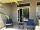 Covered patio features dual seating, small table, and sliding door access to the home at 9753 Arrowcrest Ave, Las Vegas, NV 89147