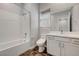 Bright bathroom featuring tub with subway tile surround and a vanity with solid surface countertop at 977 Edinburgh Fields Ct, Las Vegas, NV 89138