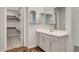 Well-lit bathroom featuring a walk-in closet, vanity, and large mirrored cabinets at 977 Edinburgh Fields Ct, Las Vegas, NV 89138