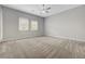 Bedroom with neutral walls, carpet, a ceiling fan, and natural light from large windows at 977 Edinburgh Fields Ct, Las Vegas, NV 89138