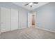 Spacious bedroom with neutral carpet, large closets, ceiling fan, and plenty of natural light at 977 Edinburgh Fields Ct, Las Vegas, NV 89138